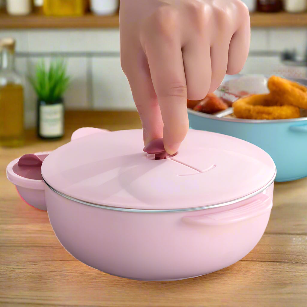 Pink food container with a hand pressing a button on the lid, set against a blurred background of food.
