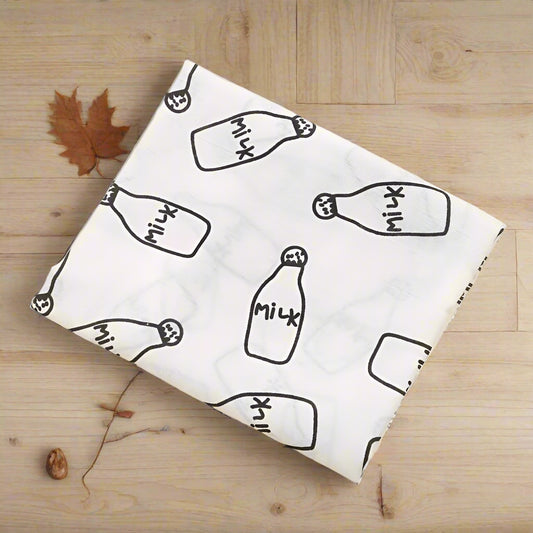 White cloth with black 'Milk' bottle pattern on a beige background